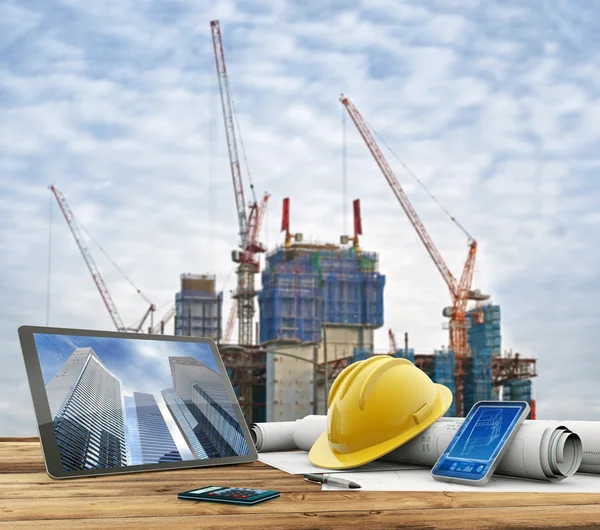 Plantas e capacete de segurança sobre uma mesa no canteiro de obras Fotografia De Stock