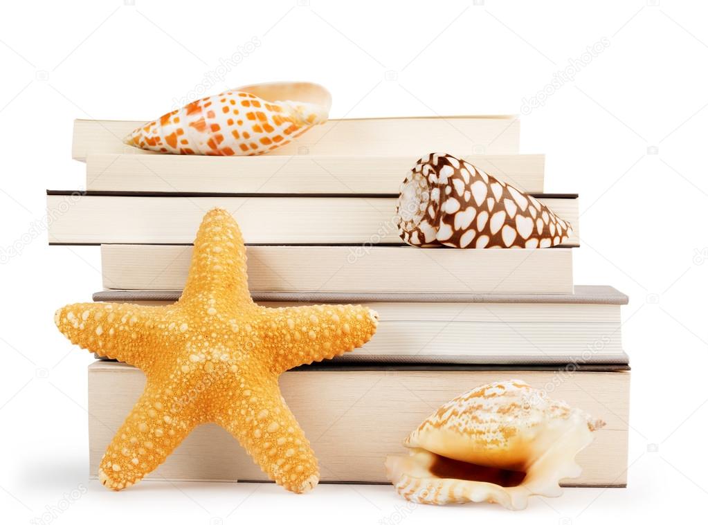 Stack of books and seashells isolated on white background