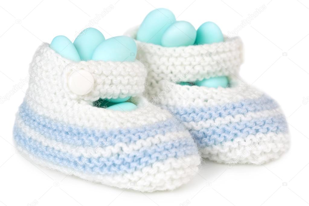 Crochet baby booties filled with blue sugared almonds