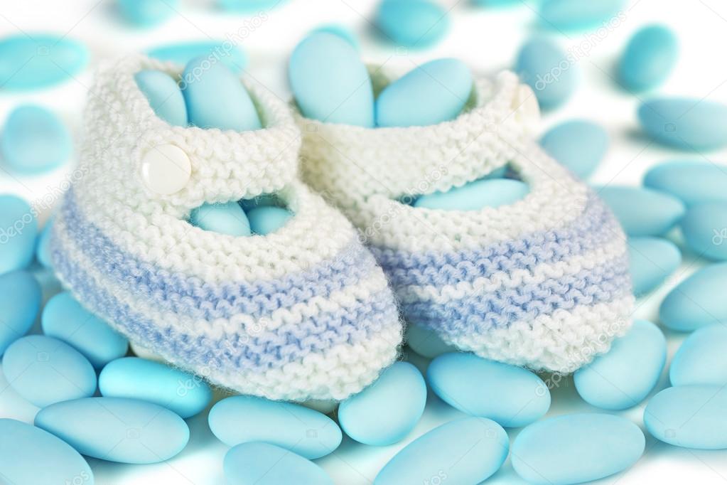Crochet baby booties over blue sugared almonds