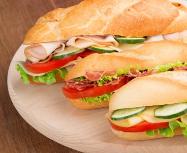 Bir kesme tahtası üzerinde tuzlu dolguları ile üç sandviç