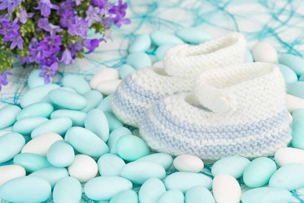 Baby shoes on white and blue sugared almonds