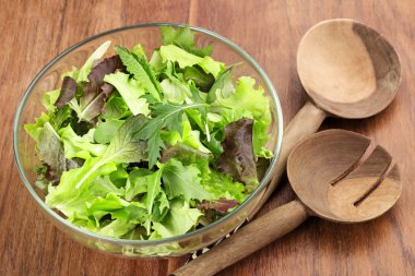 Ahşap masa üzerinde karışık salata cam kase