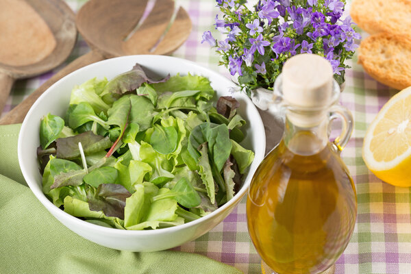 Bowl of green salad, olive oil and lemon