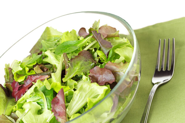 Close up of mixed salad, fork and napkin