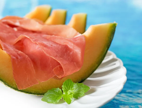 Zamknij się z szynka i melon przyozdobionym z liści mięty — Zdjęcie stockowe