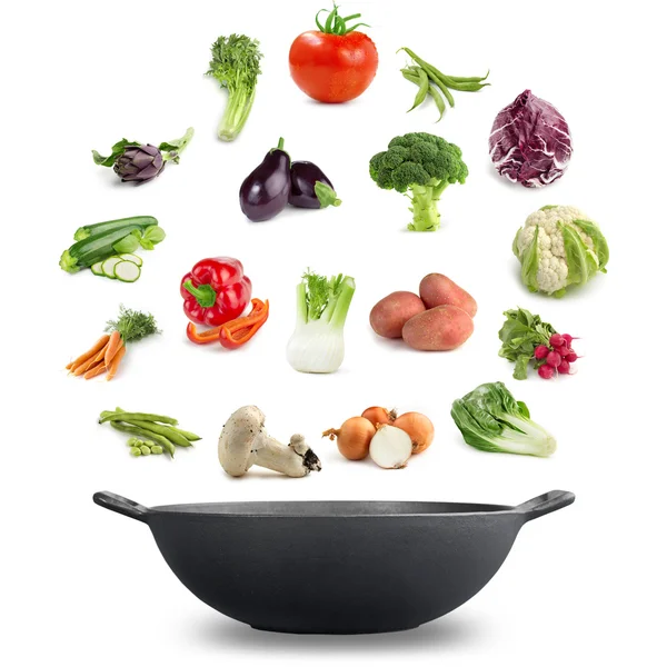 Vegan cuisine concept: varieties of vegetables above an iron pot — Stockfoto