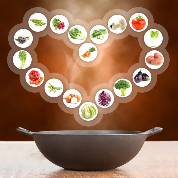 Vegetables in a heart shape over cast iron pot — Stock Image Vegetables in a heart shape over cast iron pot Royalty Free Stock Images