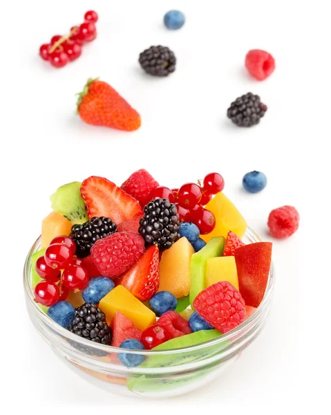 Portion of vibrant fruit salad and scattered fruits on white background — 图库照片