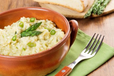 Risotto ile kuşkonmaz pişmiş toprak kapta yeşil peçete üzerinde