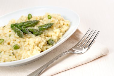 Risotto ile kuşkonmaz bir peçete ve çatal tabak