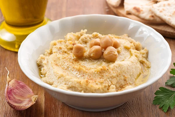 Tigela com hummus, ingredientes e fatias de pita — Fotografia de Stock