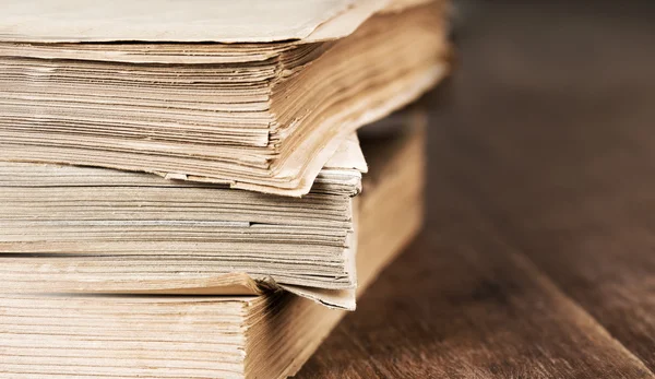 Стопка старых книг, изолированных на деревянном столе — стоковое фото