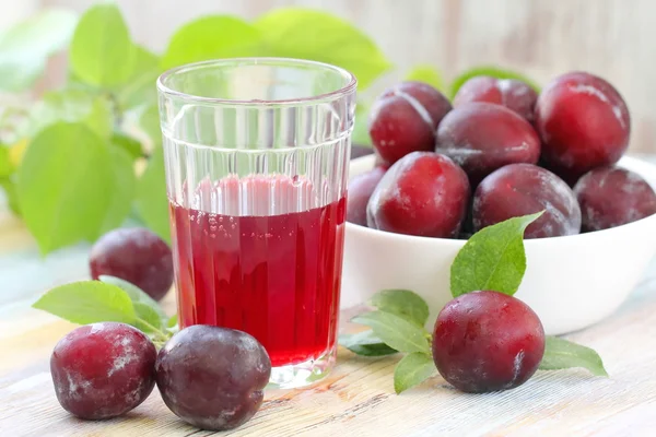 Fresh fruit juice and red plums — Stock Photo, Image