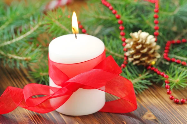 Burning candle on the christmas tree background — Stock Photo, Image