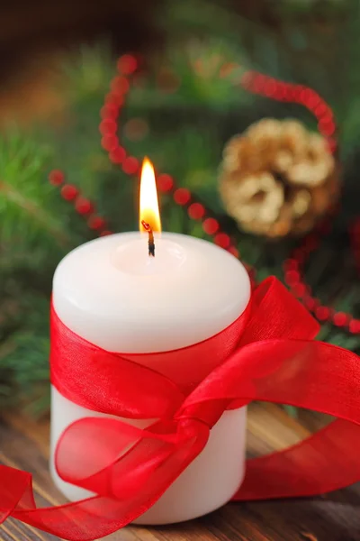 Burning candle on the christmas tree background — Stock Photo, Image