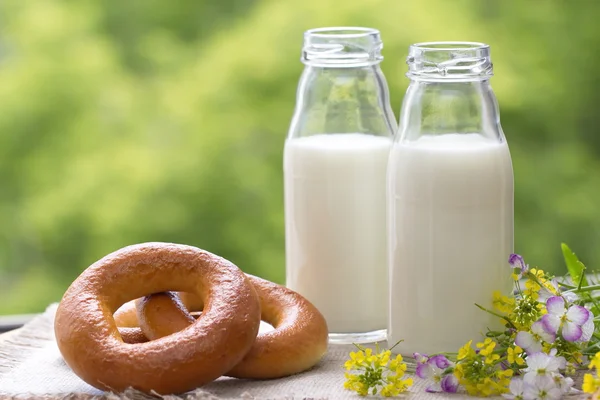 Bottle of milk and bagels in summer time — Stock fotografie