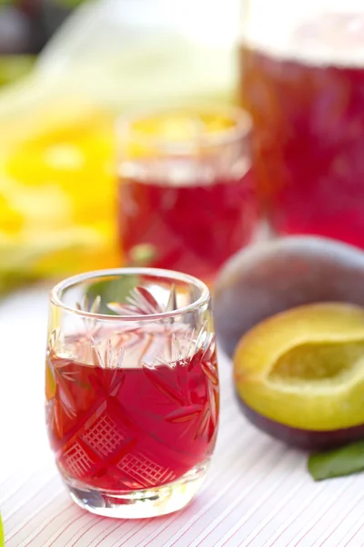 Bicchieri di alcol di prugne con prugne fresche — Foto Stock