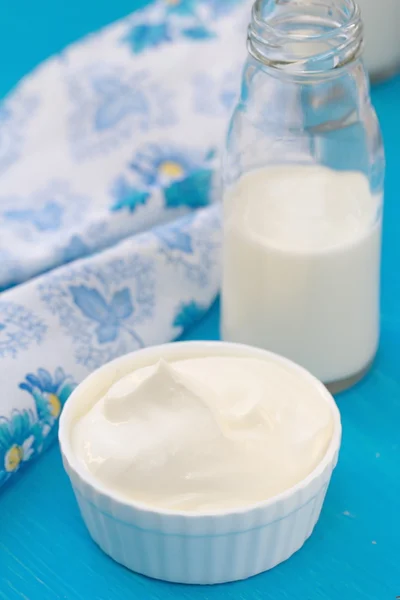 Świeże wyroby mleczne na niebieskim drewnianym stołem — Zdjęcie stockowe