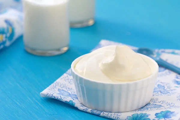 Frische Milchprodukte auf einem blauen Holztisch — Stockfoto