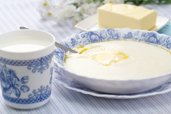 Gachas de sémola con mantequilla fresca y taza de leche — Foto de Stock