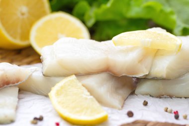 Sebzeler, limon ve baharat ahşap masa üzerinde çiğ balık