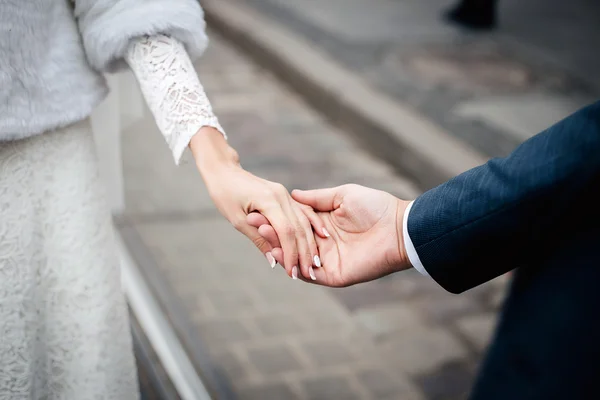 Brud- och brudgummen håller händerna utomhus — Stockfoto