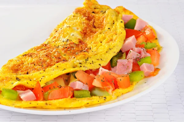Delicioso omelete com tomate, pimenta, presunto, manjericão — Fotografia de Stock