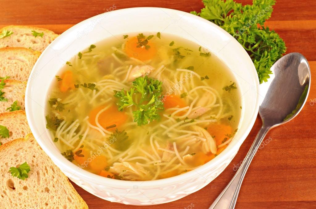 Bowl with chicken soup with vegetables and chicken meat, toasted