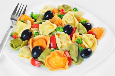 Tortellini, zeytin, brokoli, kırmızı biber, bir plaka üzerinde yapılmış salata