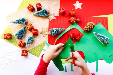 Beyaz arka planda noel işleriyle oynayan bir çocuk. Noel kutlaması. Beyaz arka plan. Mutlu, neşeli bir aile. Ev dekorasyonu. Noel hediyesi. 