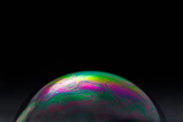 黑色背景上的彩虹肥皂泡彩色表面的特写 — 图库照片