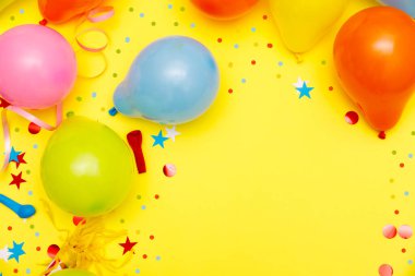 Sarı masa manzaralı renkli balonlar ve konfetiler. Şenlik ya da parti geçmişi. Düz yatış stili. Doğum günü tebrik kartı. Karnaval.