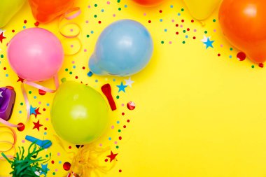 Sarı masa manzaralı renkli balonlar ve konfetiler. Şenlik ya da parti geçmişi. Düz yatış stili. Doğum günü tebrik kartı. Karnaval.