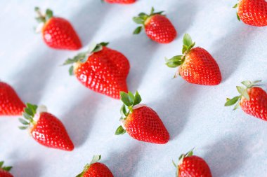 Mavi arka planda kırmızı organik çilek deseni..