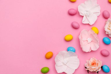 Paskalya tavşanı. Mutlu Paskalya tatili arka plan kavramı. Düz, ofis masasındaki modern kırsal pembe pastel kağıtta kutlama için aksesuarlı renkli tavşan yumurtası yatıyordu..