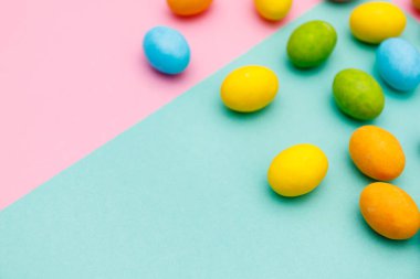 Paskalya tavşanı. Mutlu Paskalya tatili arka plan kavramı. Düz, ofis masasındaki modern kırsal pembe pastel kağıtta kutlama için aksesuarlı renkli tavşan yumurtası yatıyordu..