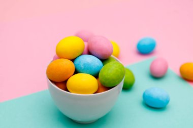 Paskalya tavşanı. Mutlu Paskalya tatili arka plan kavramı. Düz, ofis masasındaki modern kırsal pembe pastel kağıtta kutlama için aksesuarlı renkli tavşan yumurtası yatıyordu..