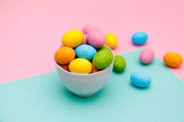 Paskalya tavşanı. Mutlu Paskalya tatili arka plan kavramı. Düz, ofis masasındaki modern kırsal pembe pastel kağıtta kutlama için aksesuarlı renkli tavşan yumurtası yatıyordu..