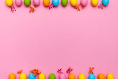 Paskalya tavşanı. Mutlu Paskalya tatili arka plan kavramı. Düz, ofis masasındaki modern kırsal pembe pastel kağıtta kutlama için aksesuarlı renkli tavşan yumurtası yatıyordu..