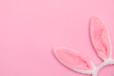 Paskalya tavşanı. Mutlu Paskalya tatili arka plan kavramı. Düz, ofis masasındaki modern kırsal pembe pastel kağıtta kutlama için aksesuarlı renkli tavşan yumurtası yatıyordu..