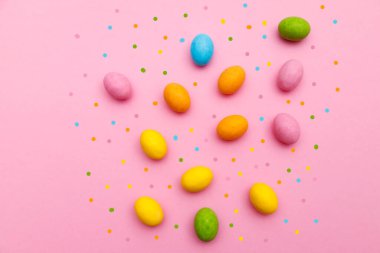 Paskalya tavşanı. Mutlu Paskalya tatili arka plan kavramı. Düz, ofis masasındaki modern kırsal pembe pastel kağıtta kutlama için aksesuarlı renkli tavşan yumurtası yatıyordu..