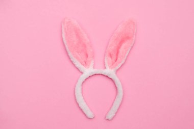 Paskalya tavşanı. Mutlu Paskalya tatili arka plan kavramı. Düz, ofis masasındaki modern kırsal pembe pastel kağıtta kutlama için aksesuarlı renkli tavşan yumurtası yatıyordu..