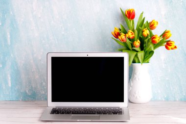 Ofis ya da çalışma odası. Masada renkli laleler. Kadınsı çalışma alanı