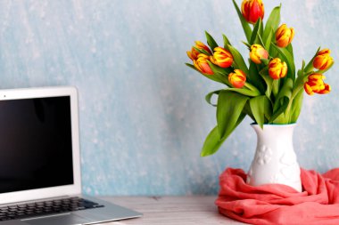 Ofis ya da çalışma odası. Masada renkli laleler. Kadınsı çalışma alanı