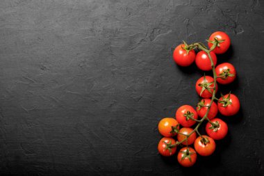 Siyah arka planda vişne domatesleri, üst manzara.