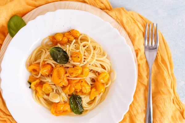 Pasta Spaghetti Dengan Tomat Kuning Piring Putih Latar Belakang Biru — Stok Foto