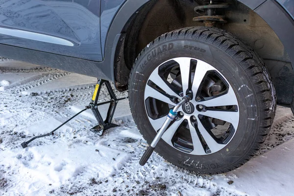 Zhukovsky, Rusya - 5 Aralık 2020: KIA Sportage, karlı bir bölgede, bir garajın yakınında tekerlek değiştirirken havaya uçtu.