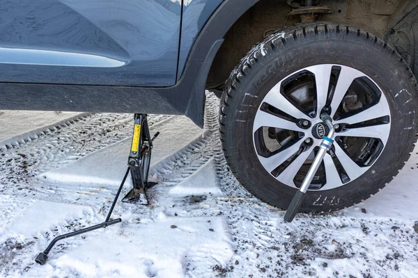 Zhukovsky, Rusya - 5 Aralık 2020: KIA Sportage, karlı bir bölgede, bir garajın yakınında tekerlek değiştirirken havaya uçtu.