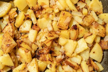 Kızartma tavasında soğanlı kızarmış patates iştahı. Yüzeysel bir alan. Seçici odak.